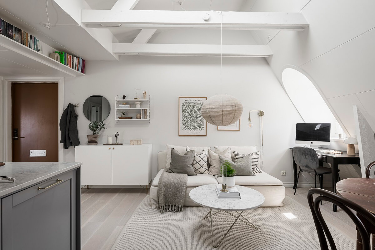 A Swedish Attic Apartment with a Lovely Balcony Overlooking the City 10 attic living room high pitched ceiling wooden beams