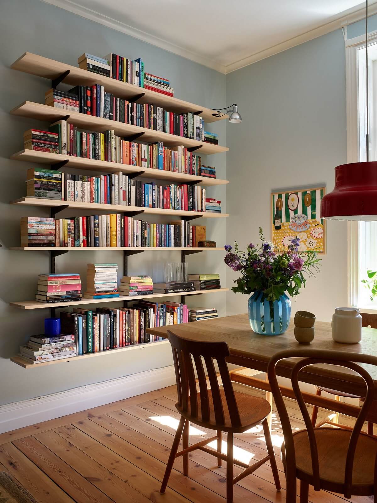 light blue walls living room with wooden dining table and bookshelves