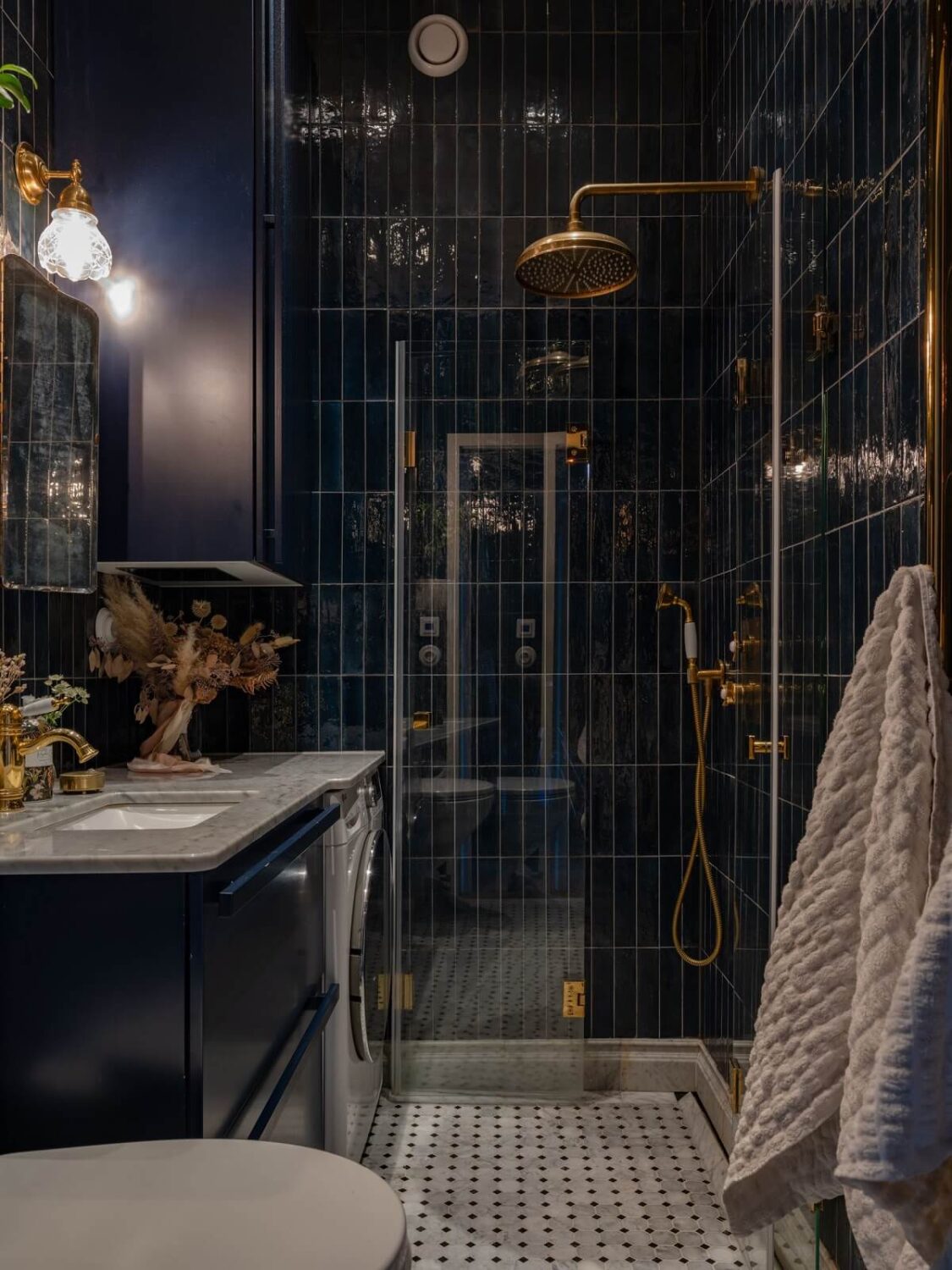 An 1890s Stockholm Apartment with a Blue Bedroom 18 moody small bathroom with dark blue tiles and brass fittings nordroom