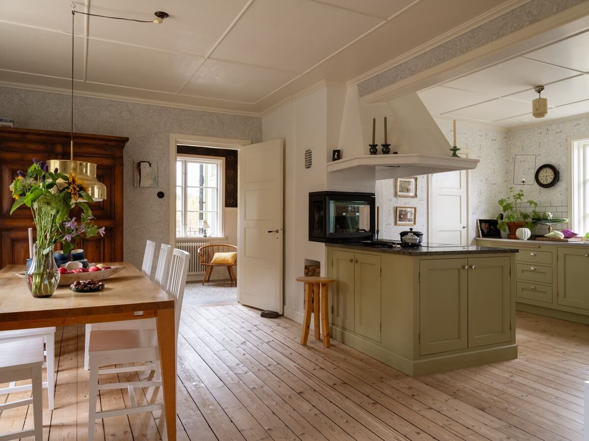 A 1930s Green-Painted Wooden Family Home in Sweden 1 open plan kitchen and dining room with wooden floorboards