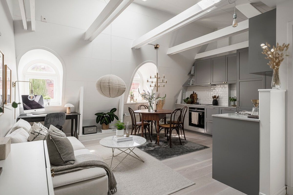 A Swedish Attic Apartment with a Lovely Balcony Overlooking the City 1 scandi attic living room exposed beams gray kitchen