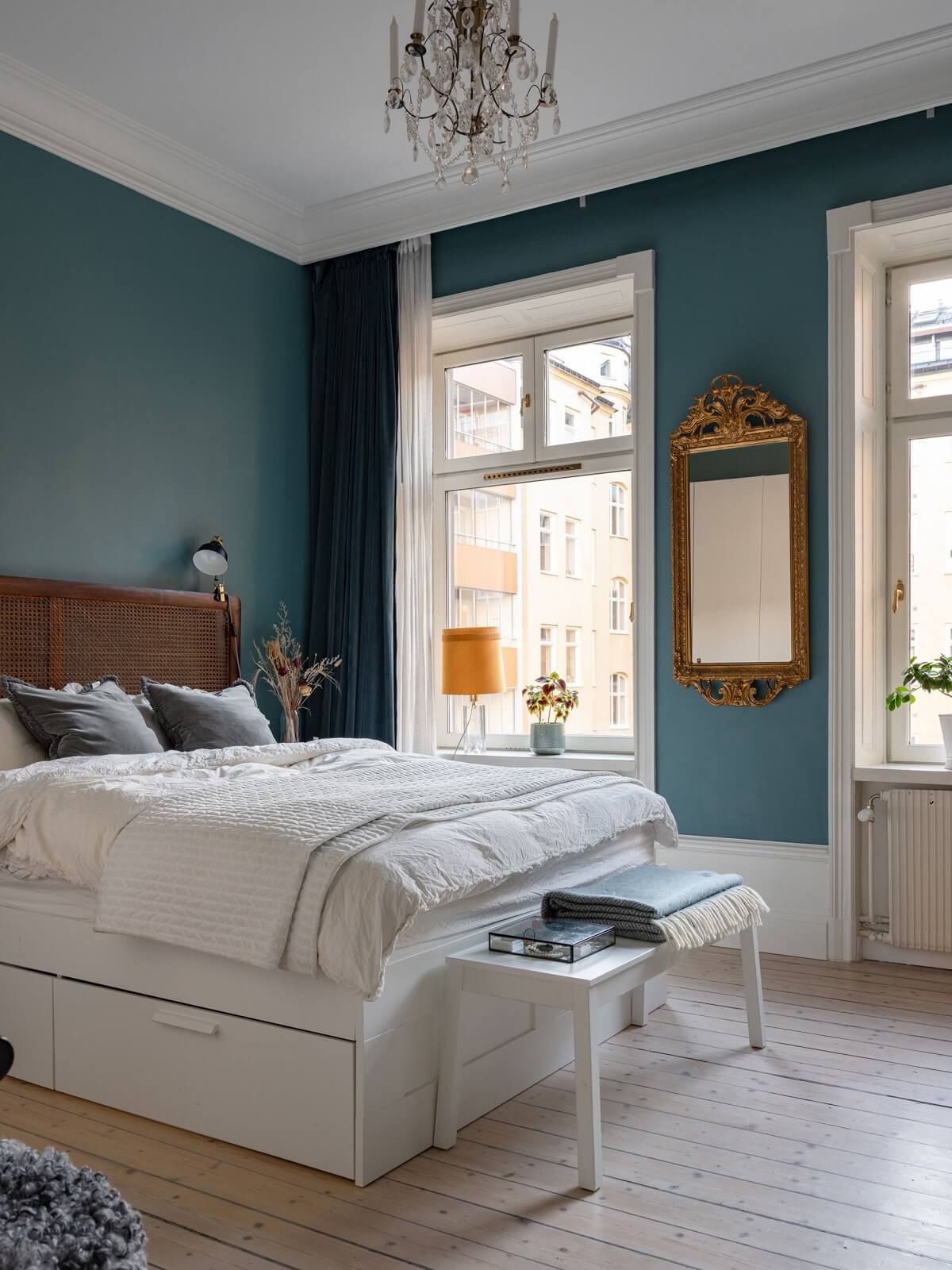 teal blue walls and cane headboard gilded mirror nordroom