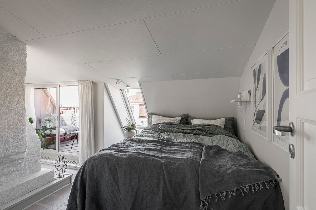 A Swedish Attic Apartment with a Lovely Balcony Overlooking the City 12 white attic bedroom with balcony
