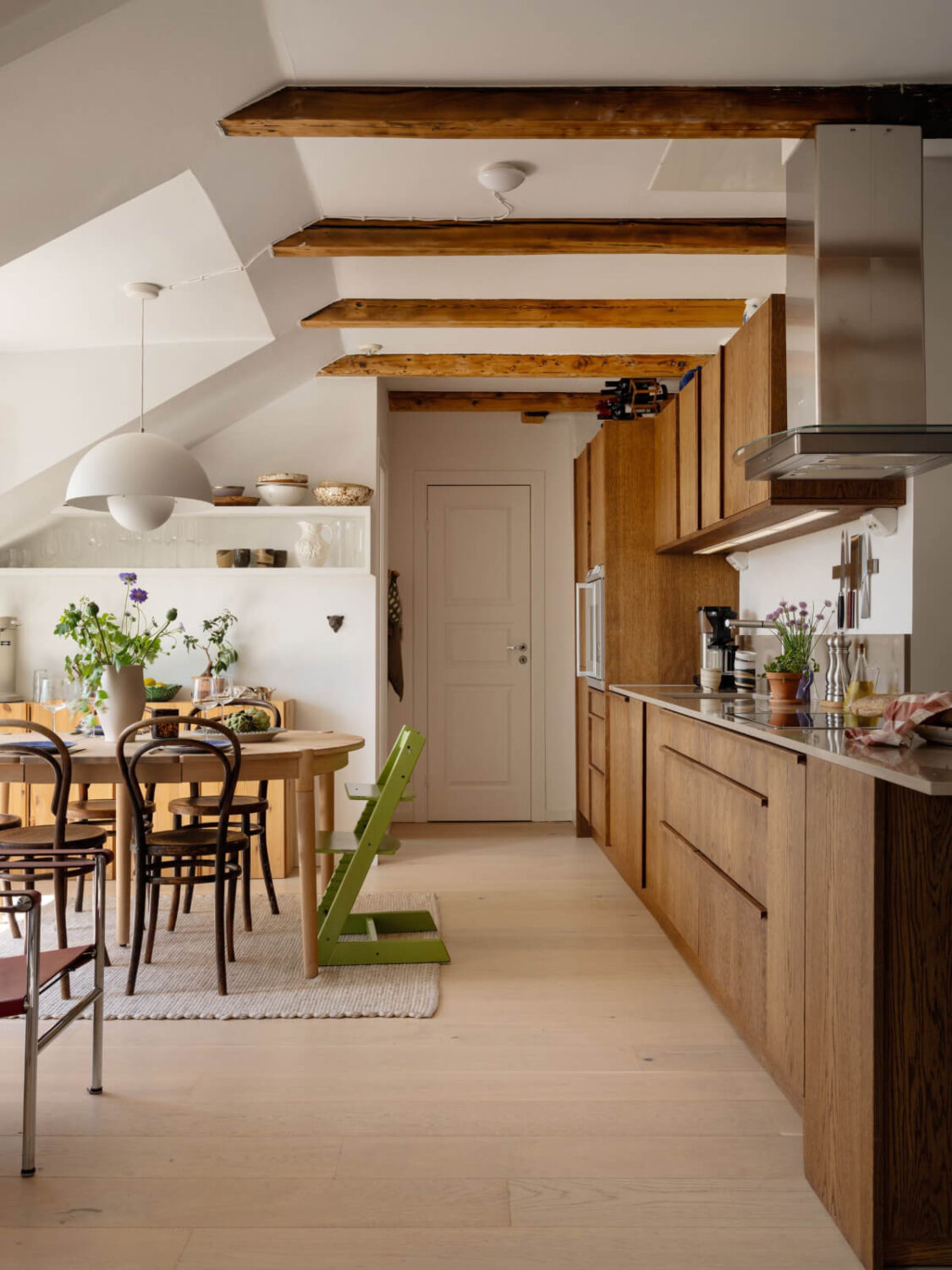 A Charming Light-Filled Attic Apartment with a Dark Oak Kitchen 2 kitchen with dining table in stockholm attic apartment