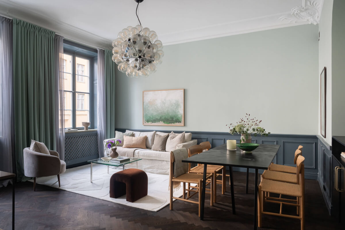 A Moody Color Palette in a Stylish One-Bedroom Apartment in Stockholm 1 living room with dark herringbone floor and wall paneling