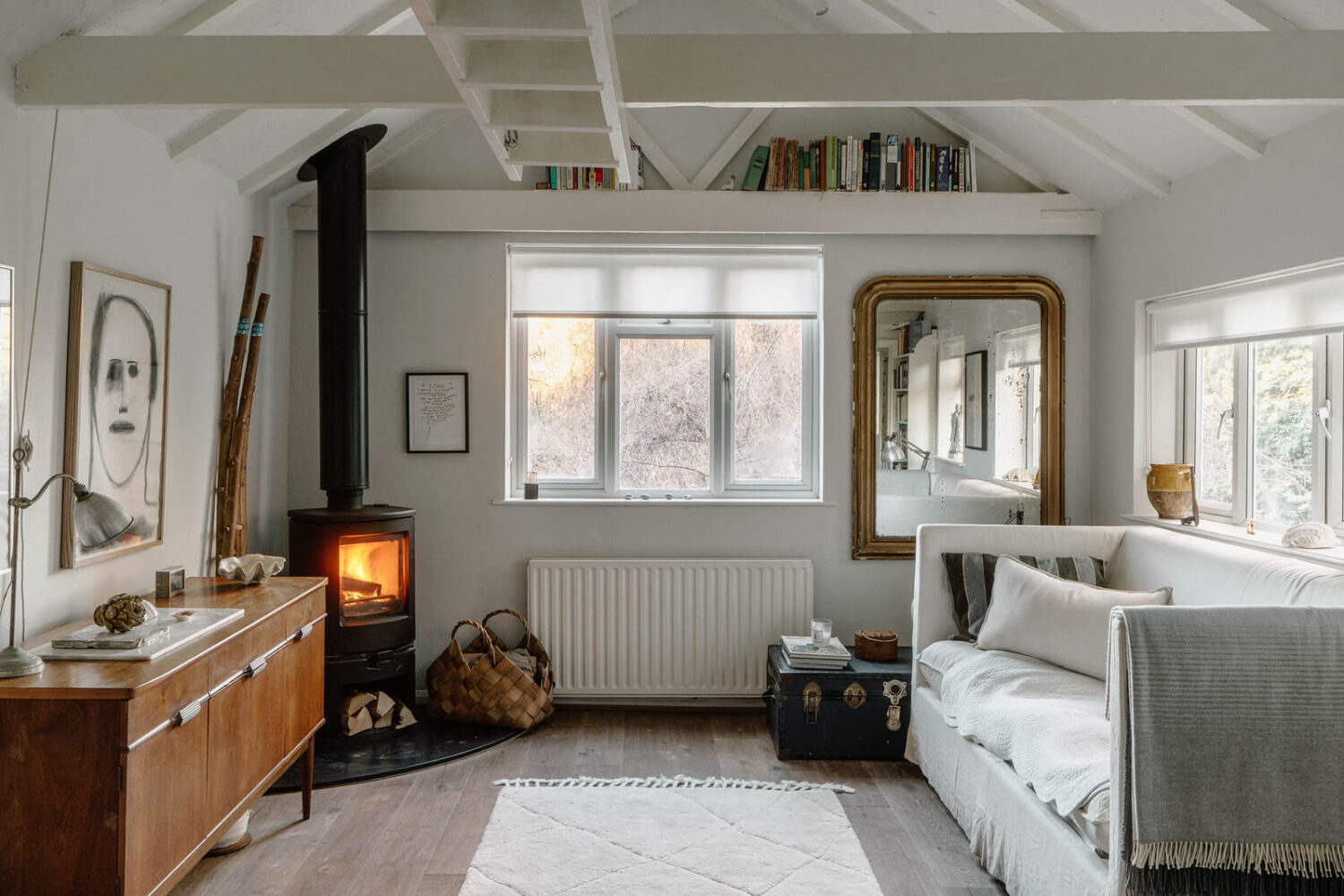 French and Midcentury Influences in a Charming London Studio Apartment 2 london studio with log burner and bookshelf above window