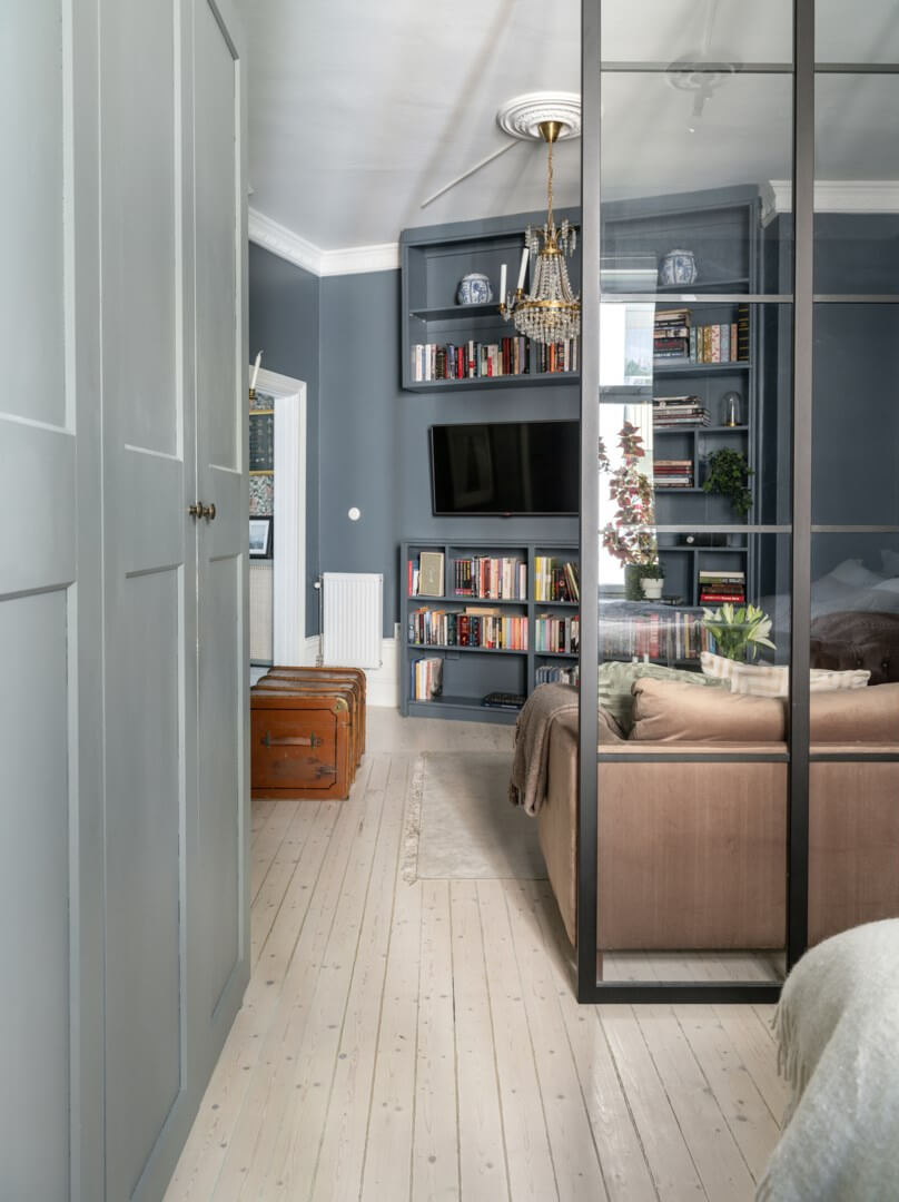 A Classic Studio Apartment with an Industrial Glass Room Divider 7 studio apartment with dark blue walls and gray wardrobes nordroom