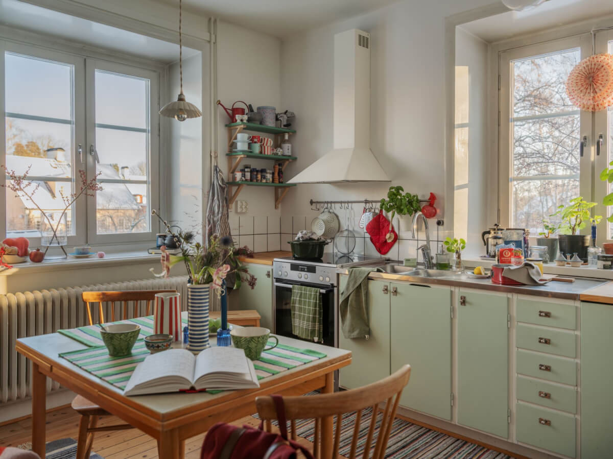 A Two-Bedroom Apartment with the Original Midcentury Kitchen 26 green midcentury kitchen with wooden floor and square vintage table