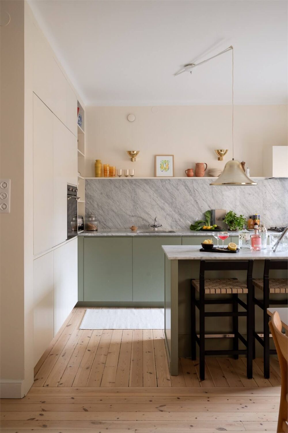 A Light-Filled Two Bedroom Apartment in Stockholm 5 kitchen green lower cabinets built-in beige high cabinets