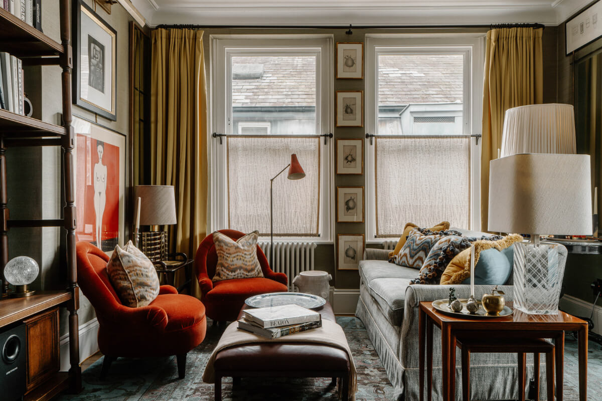 A Cozy Art-Filled Attic Apartment in London 2 warm living room with art and ochre yellow curtains