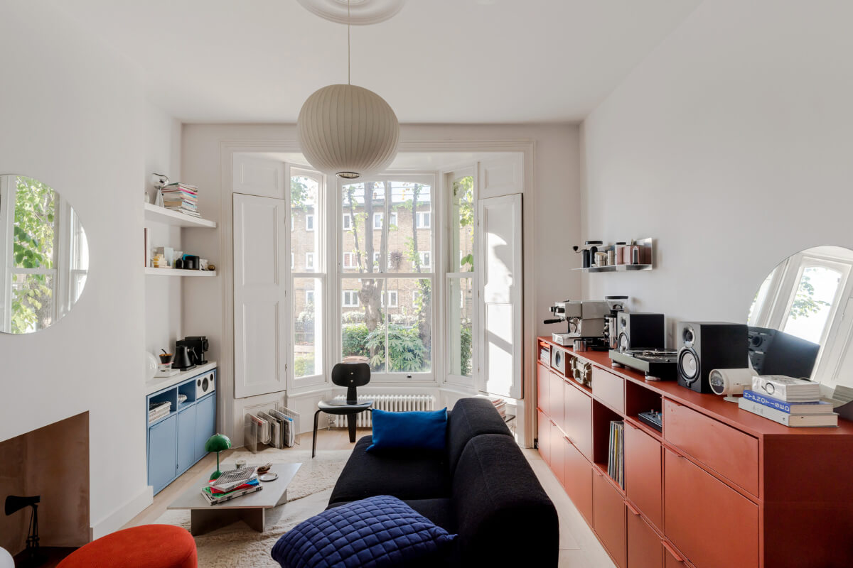 white living room bay window red and blue cabinets