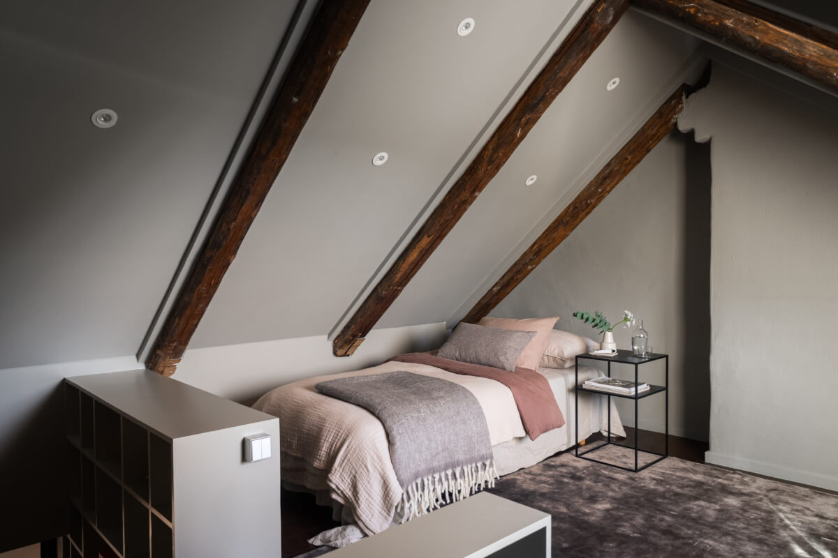 A Light Penthouse Apartment with Built-In Bookshelves 27 gray attic bedroom wooden beams