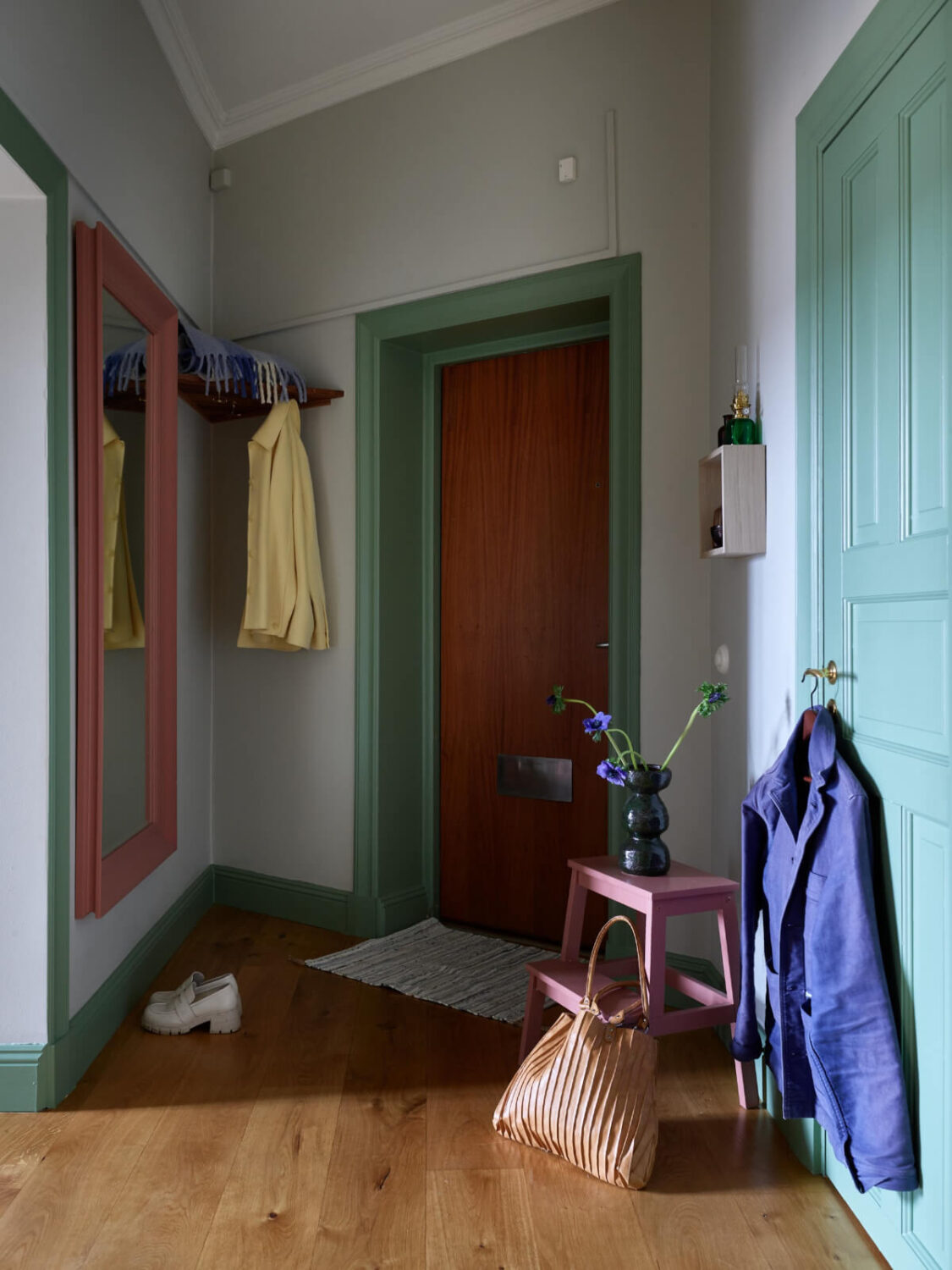 Lovely Color Combinations in a Charming One-Bedroom Apartment 23 hall green woodwork large pink mirror Lovely Color Combinations in a Charming One-Bedroom Apartment