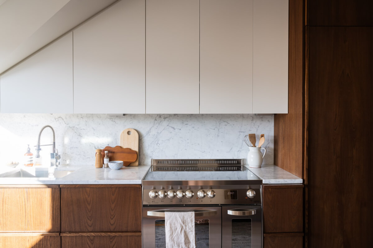 A Light Penthouse Apartment with Built-In Bookshelves 12 kitchen cabinets under slanted ceiling