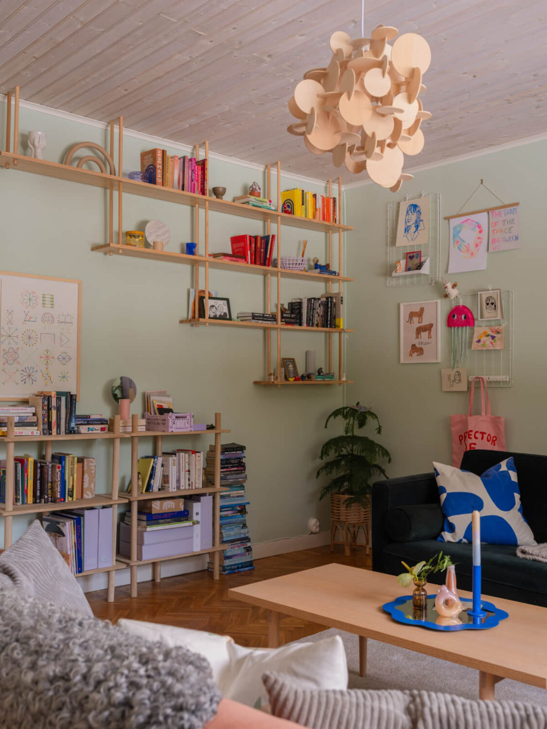 Colorful Decor in a Charming Family Duplex Apartment in Stockholm 8 light green living room with bookshelves