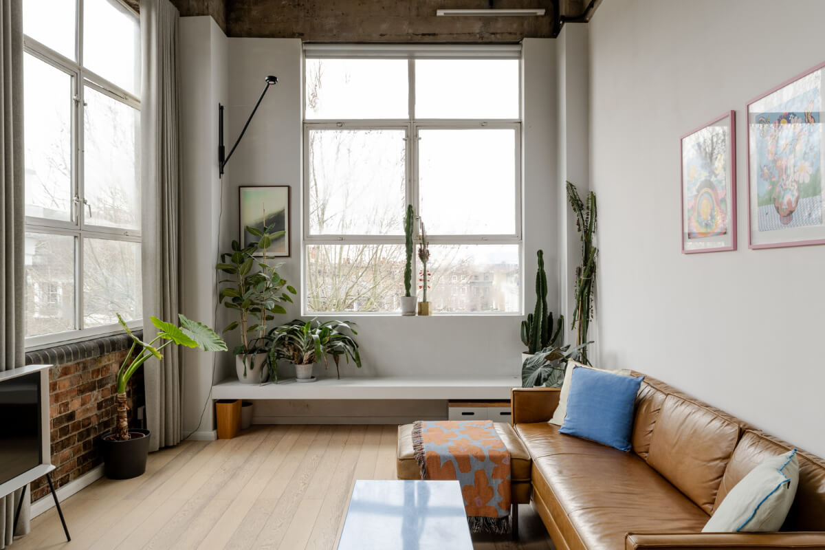 A Plant-Filled Loft Apartment in a Former Clothing Factory 2 loft living room large windows exposed brick