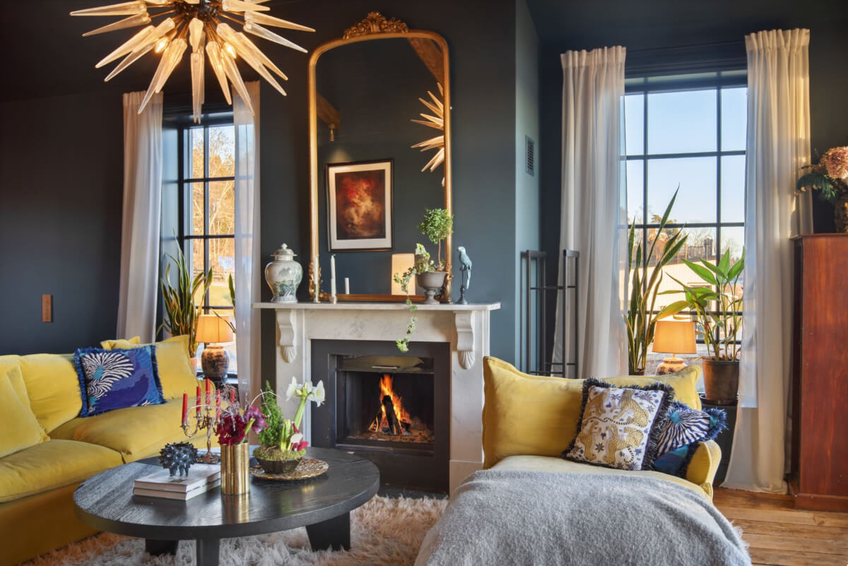 English Manor Style Interiors in a New Swedish Home with Lake Views 2 moody sitting room fireplace ochre yellow seating