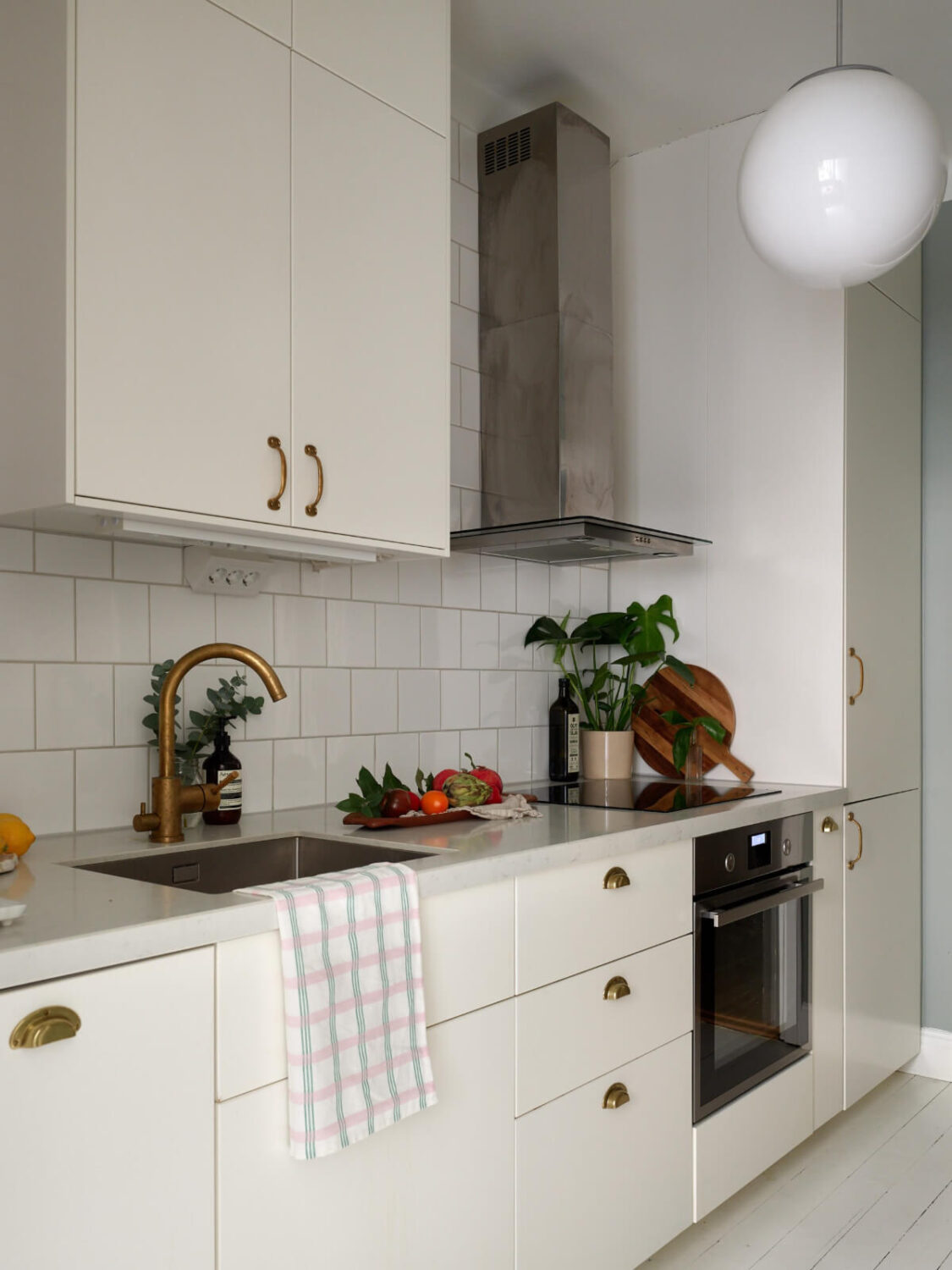 A Charming Small Apartment with a Fresh White Kitchen 12 small white kitchen brass fittings