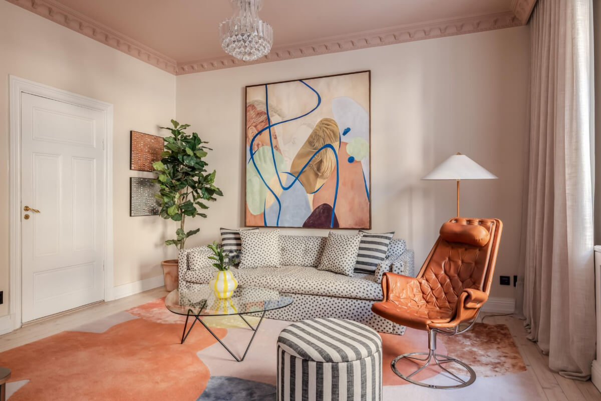 Pastel Colors and Contemporary Design in a Late 19th Century Apartment 1 two tone pink living room large pastel rug dotted sofa striped ottoman