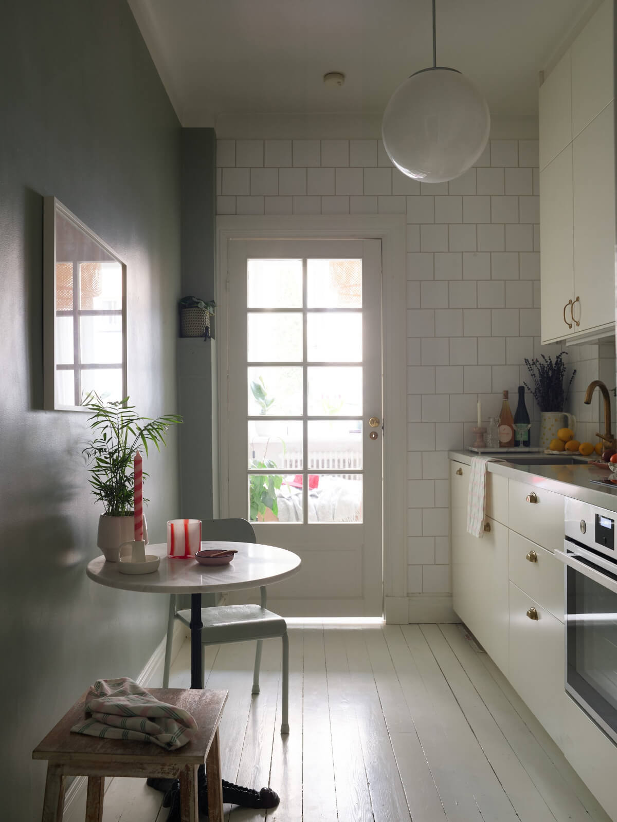 white kitchen with small round table and glass door
