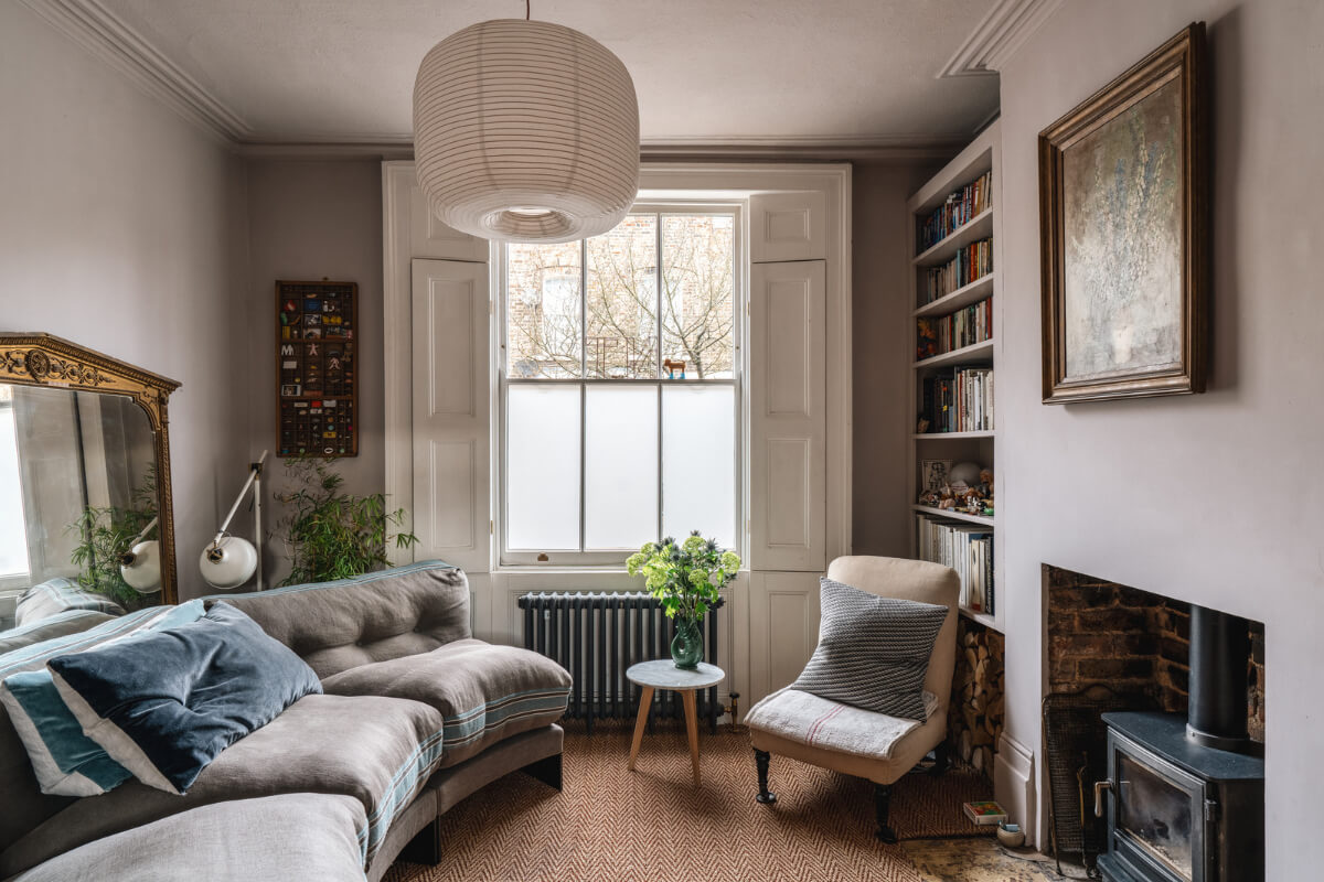 A Cozy Victorian Home Painted in Moody Blue and Gray Tones 1 gray living room log burner window shutters
