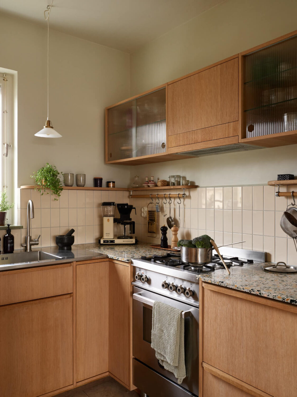 A Renovated 1940s Apartment with Colorful Bedrooms 11 oak kitchen with terrazzo countertop and beige backsplash tiles