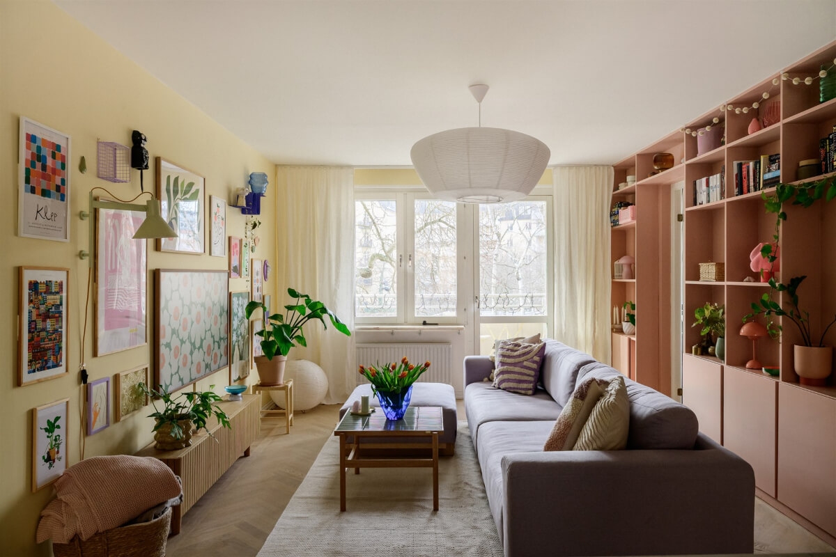 Colorful Rooms in a Bright Two-Bedroom Stockholm Apartment 2 pink and yellow living room bookshelves gallery wal