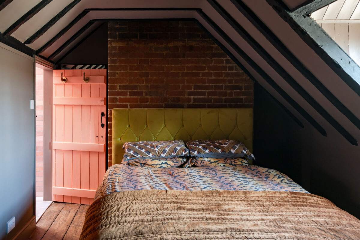 Colorful Design and Historic Features in a Charming English Home 23 attic bedroom wooden beams exposed brick wall nordroom