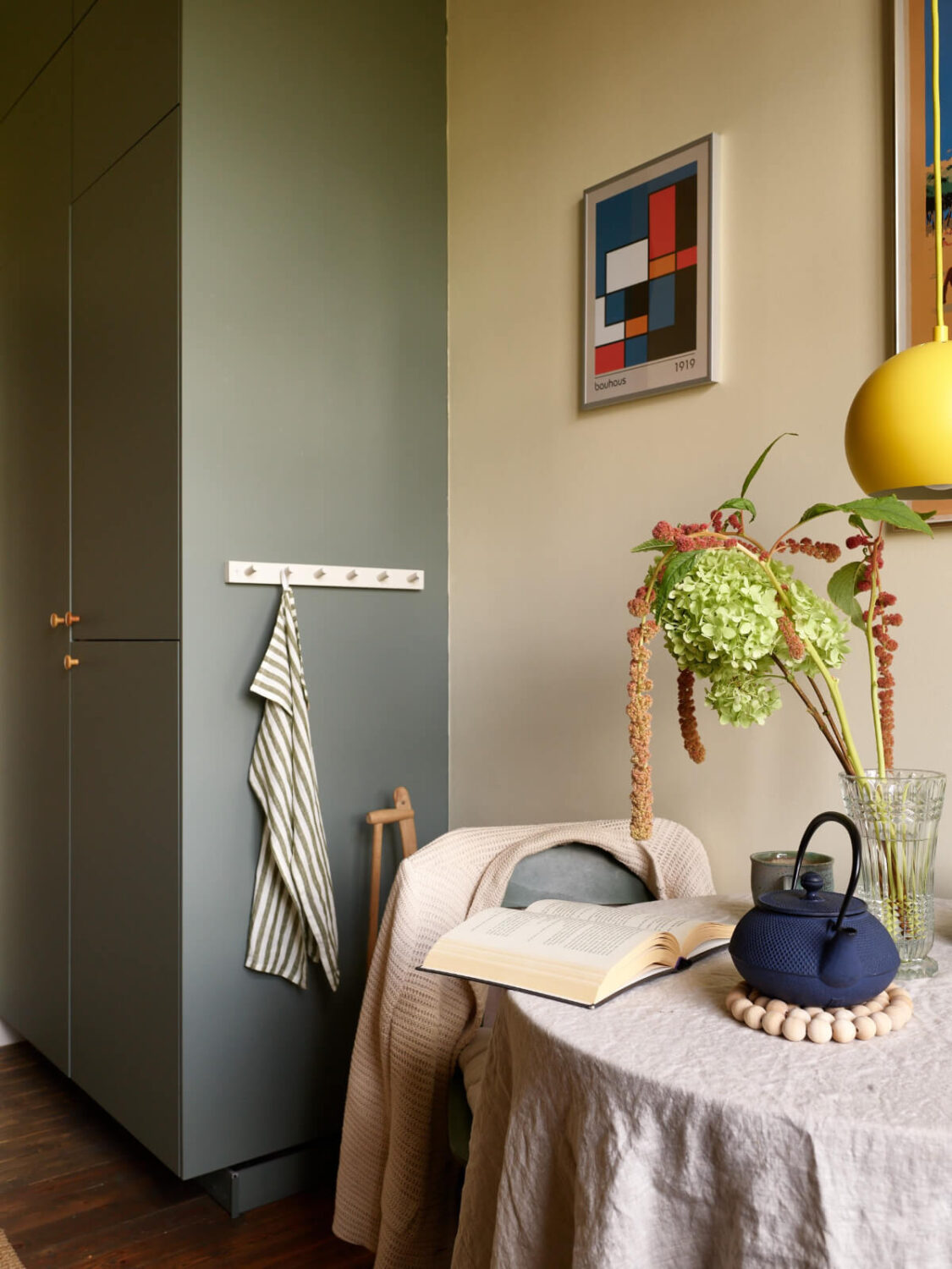 A Nature-Inspired Color Palette in a Stockholm Apartment 11 floor to ceiling kitchen cabinets small round table yellow pendant light