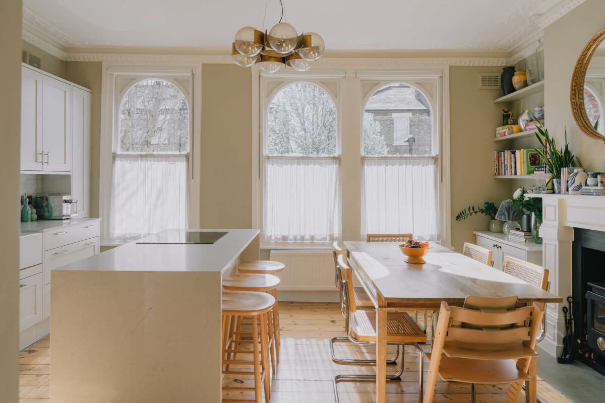 A Serene Color Palette and Built-In Shelves in a London Duplex 5 open plan kitchen dining area fireplace wooden floor