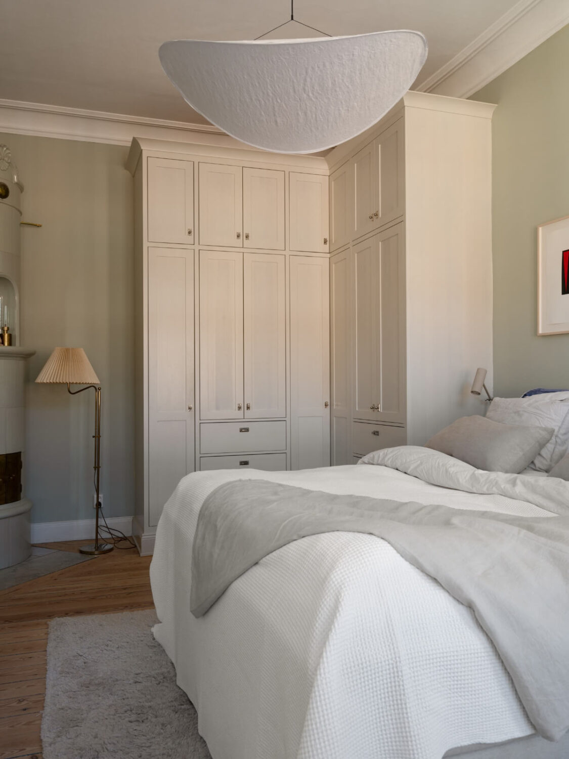 Turn-of-the-Century Charm and Site-Built Storage in a Stockholm Apartment 15 serene bedroom gray-green walls corner built-in wardrobes