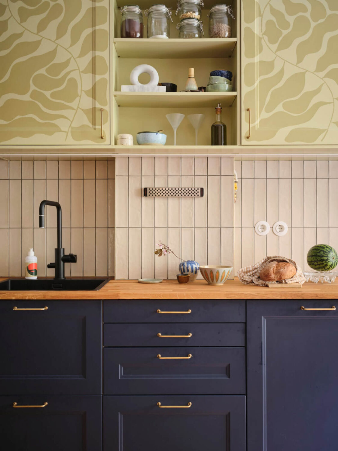 A Fantastic Small Art Nouveau Apartment in Stockholm 5 blue and patterned green kitchen cabinets beige backsplash tiles wooden countertop nordroom