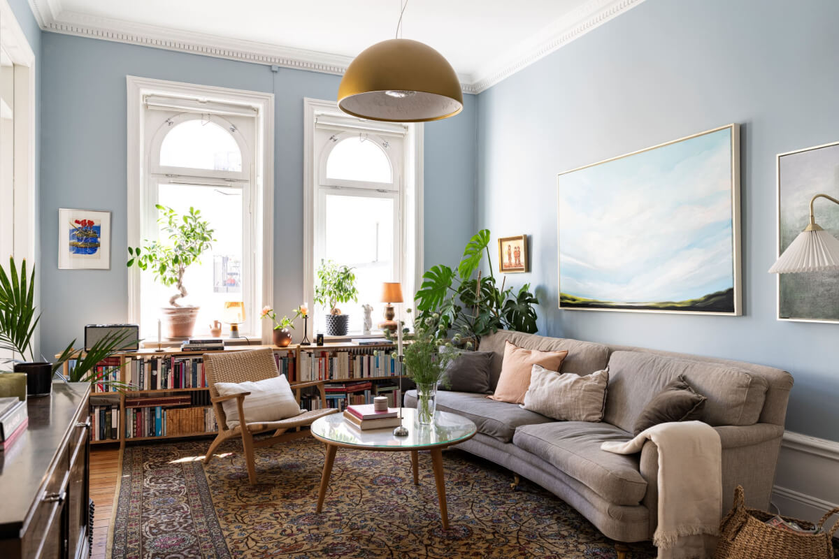 Wallpapers and Blue Tones in a Cozy Turn-of-the-Century Home 1 blue living room bookcases under windows