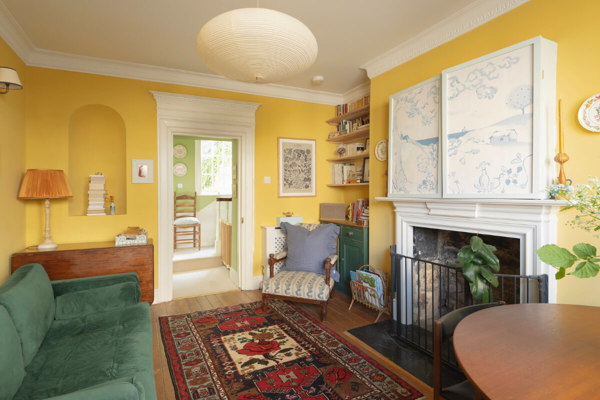 A Family Home with a Cheerful Color Palette in a Historic House 5 cozy yellow living room with fireplace and bookshelves