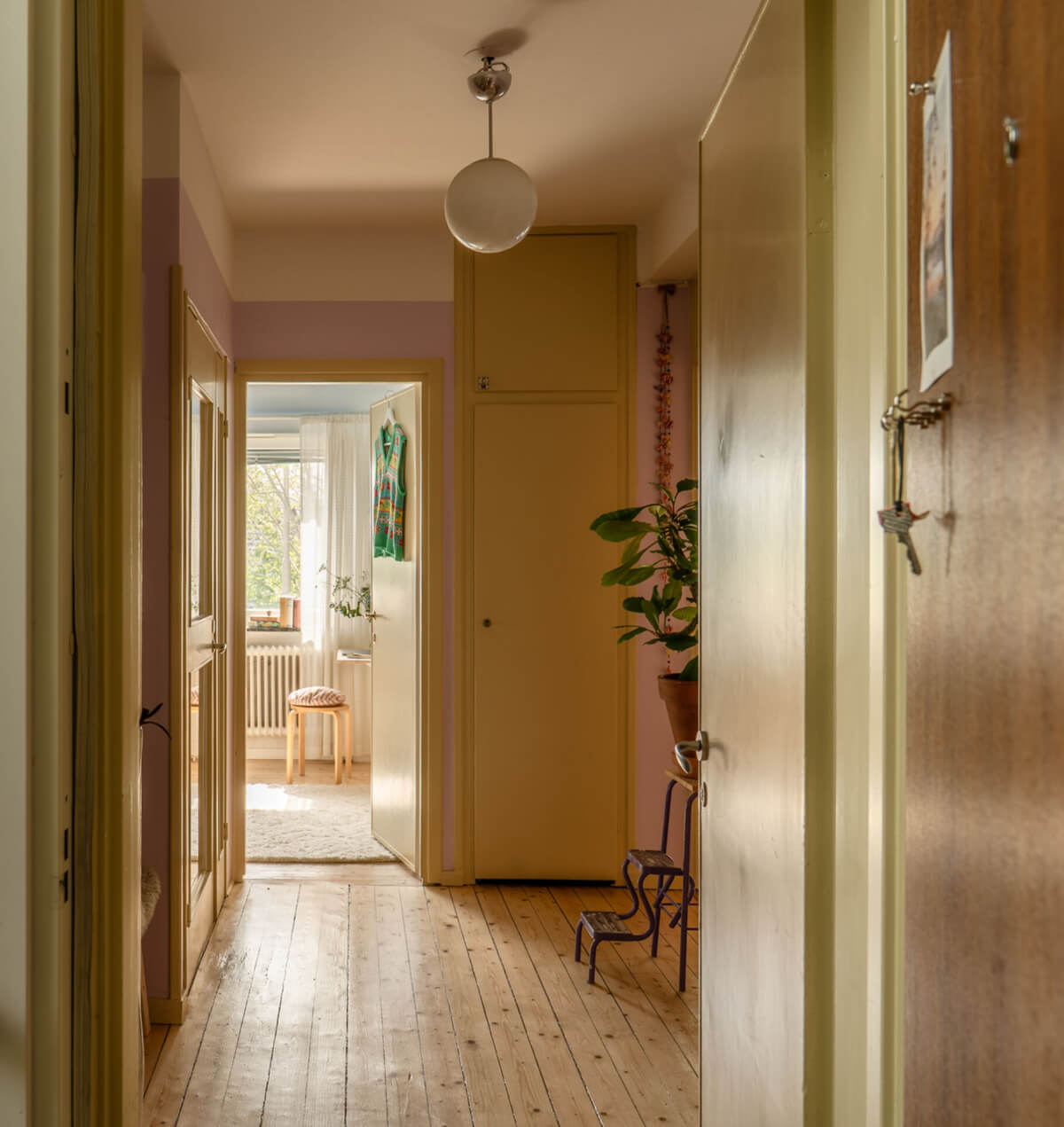 A Stylish and Joyful Color and Material Palette in a Midcentury Apartment 30 hall butter yellow woodwork