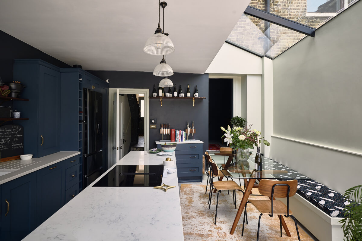 Moody Tones in a Restored and Extended Victorian Home in London 1 kitchen extension dark blue cabinets skylight glass dining table