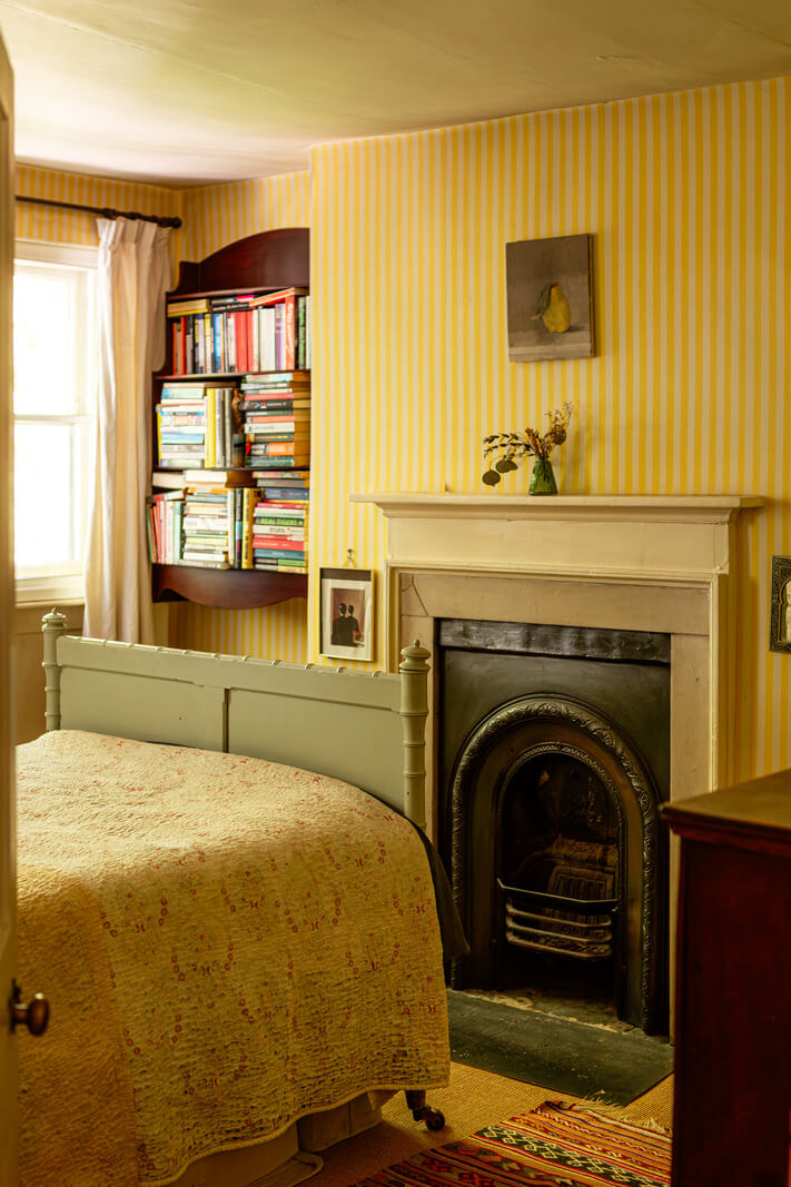 A Carefully Restored Georgian Townhouse in East London 21 striped yellow wallpaper fireplace bedroom