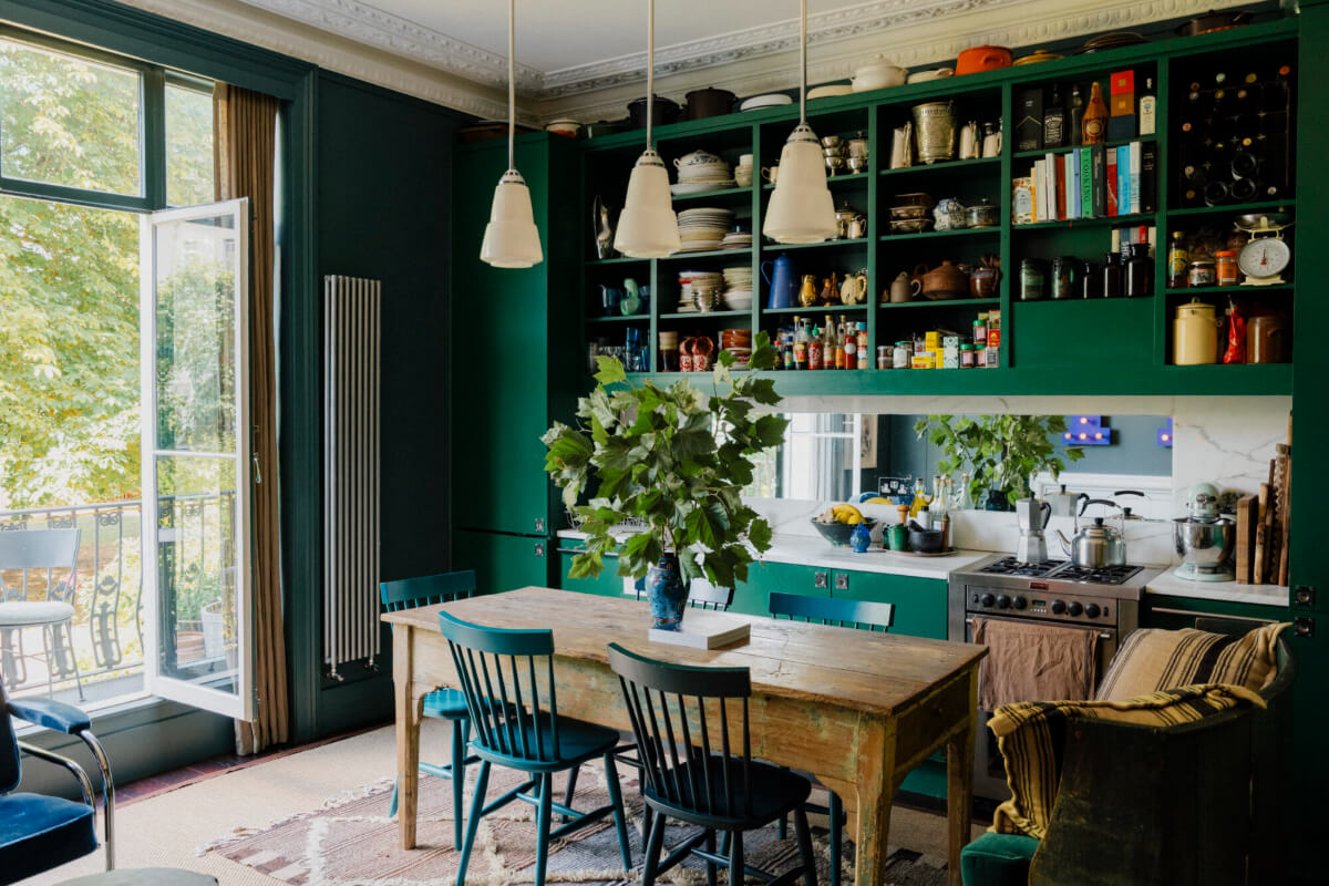 A Rich Color and Material Palette in a Small Victorian Apartment 1 green kitchen open upper cabinets rustic wooden table