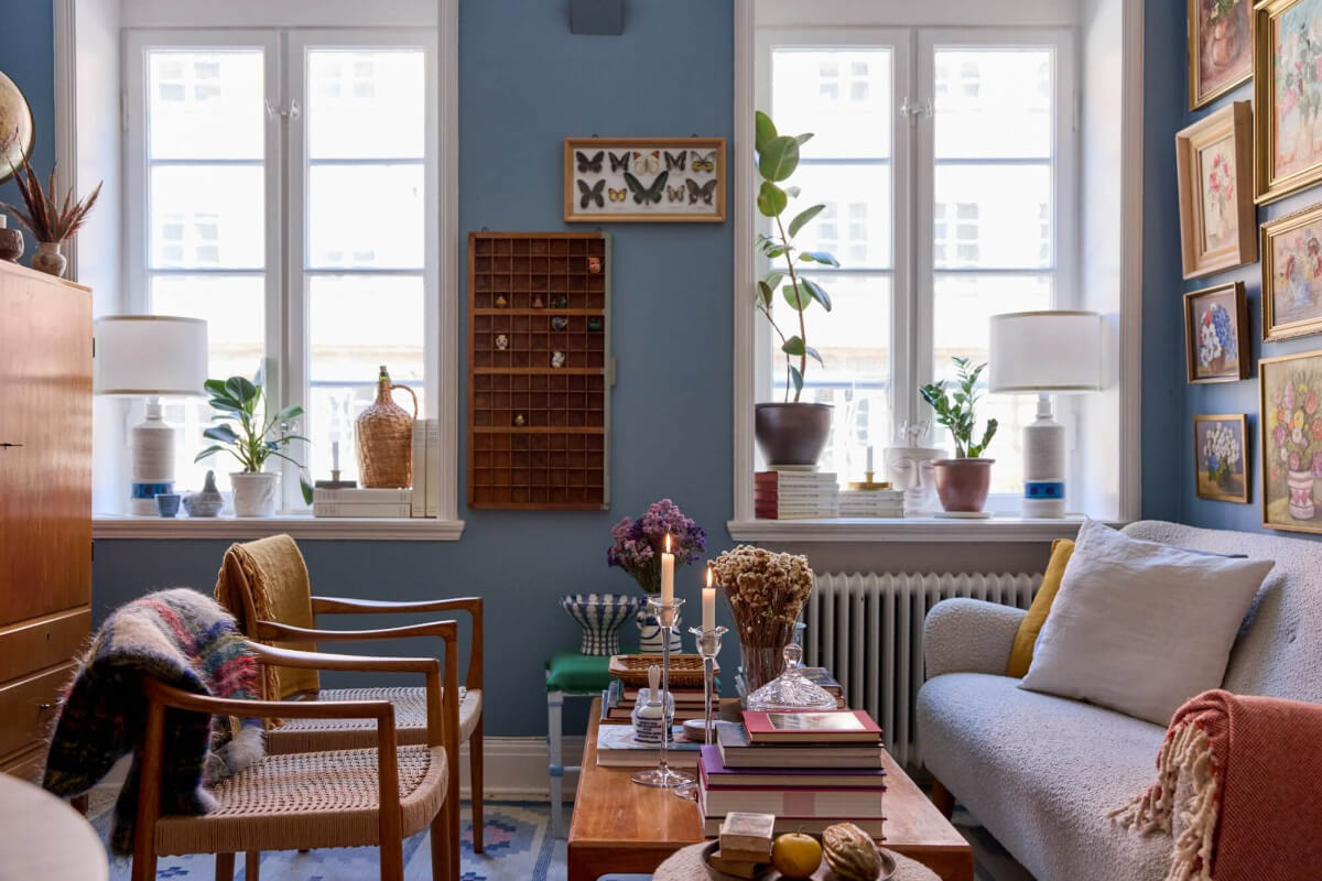 A Blue Living Room Filled with Art in a Swedish Apartment 2 blue sitting room gallery wall with floral art