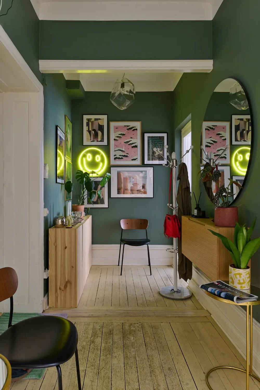 A Colorful Stockholm Apartment with a Large Terrace 22 green hall with gallery wall and large round mirror