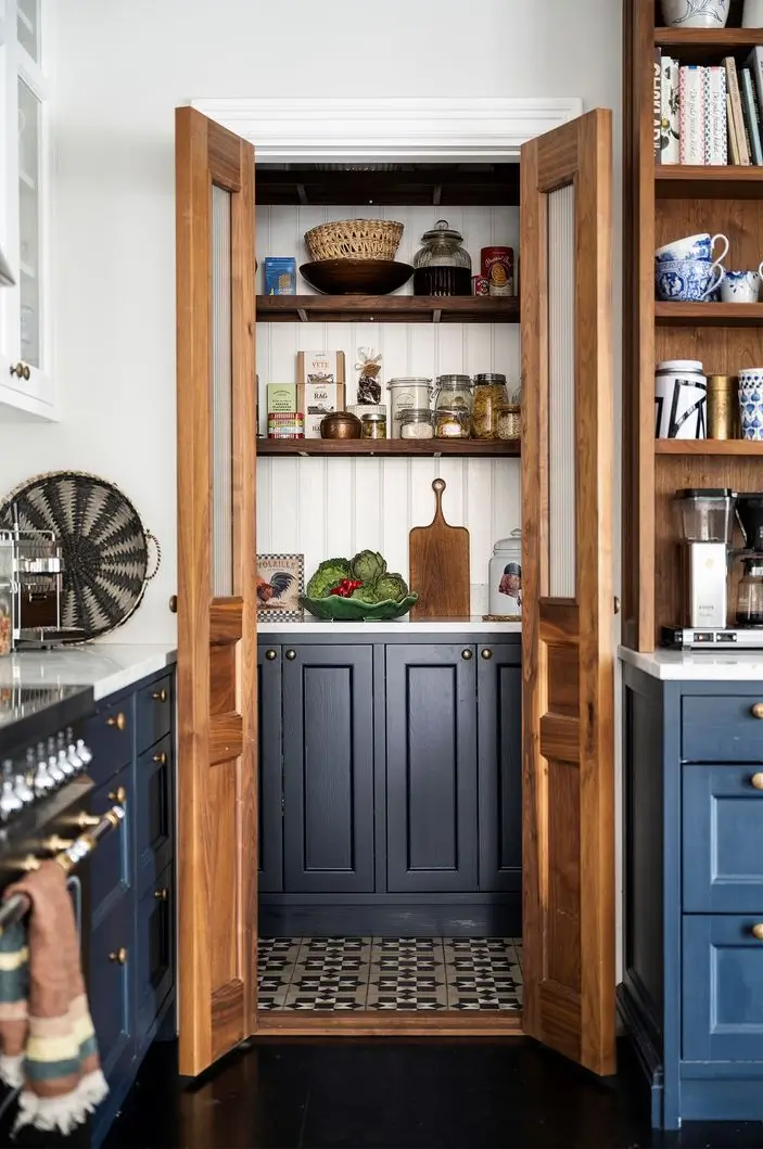 Scandinavian Design Meets The Hamptons in a Swedish Country House 19 kitchen view into pantry wooden doors nordroom