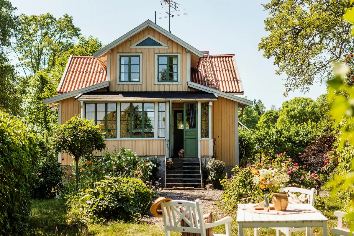 yellow swedish country house lush garden