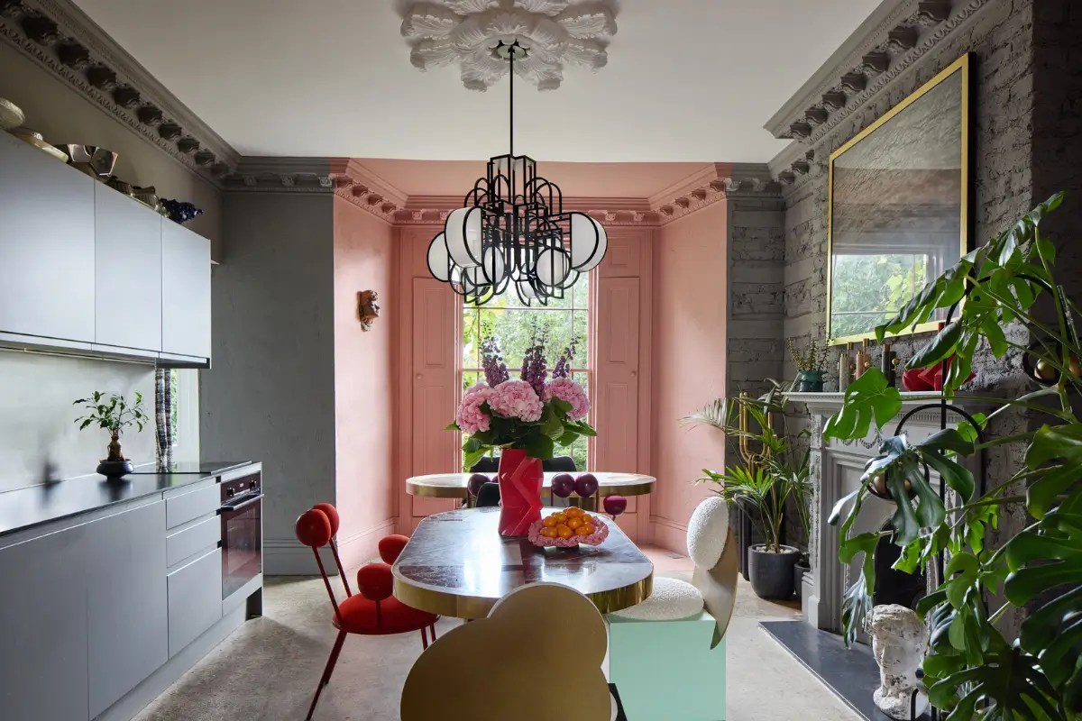 Victorian Grandeur Meets Modern Design in a Camden Square Townhouse 5 gray kitchen with table and pink bay window