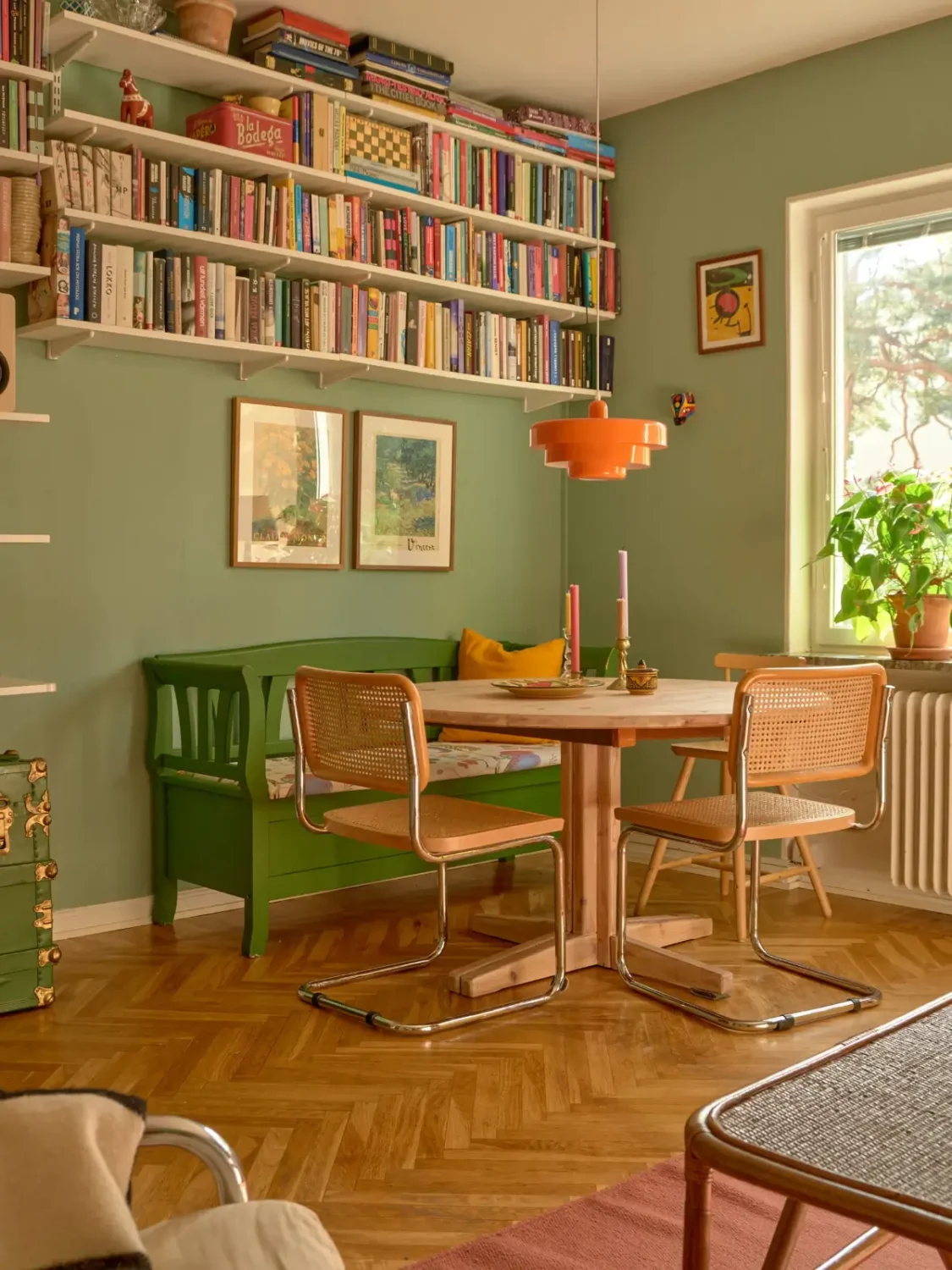 A Colorful and Cozy Midcentury Apartment in Stockholm 5 green living room round wooden floor bookshelves nordroom