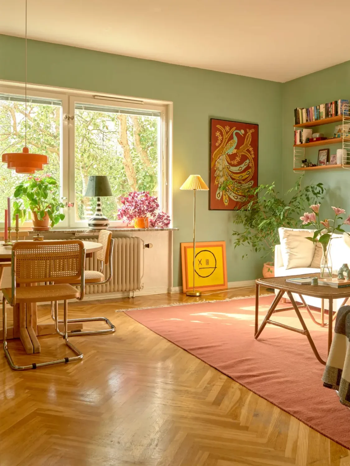 A Colorful and Cozy Midcentury Apartment in Stockholm 4 living room herringbone floor green walls