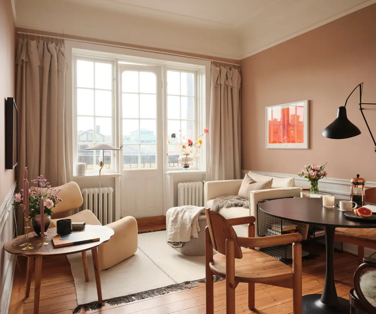 Warm Pink Walls and a Glass Room Divider in a Small Stockholm Apartment 1 small pink living room wooden floor balcony door nordroom
