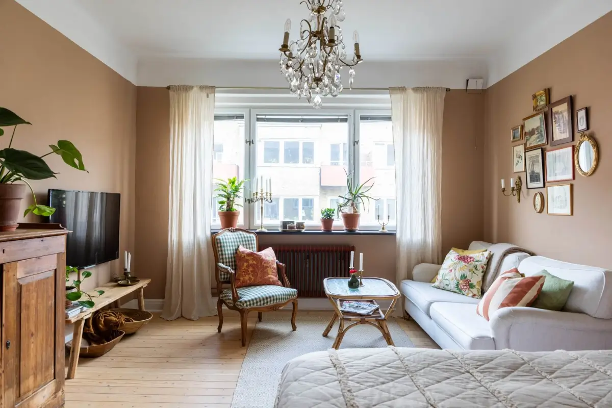 Warm Tones, Antiques, and Period Features in a Swedish Studio Apartment 1 studio apartment warm wall color wooden floorboards