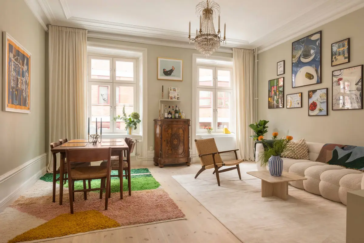 A Stylish Beige Apartment with a Light Blue Kitchen 1 living room wooden floor beige walls colorful rug
