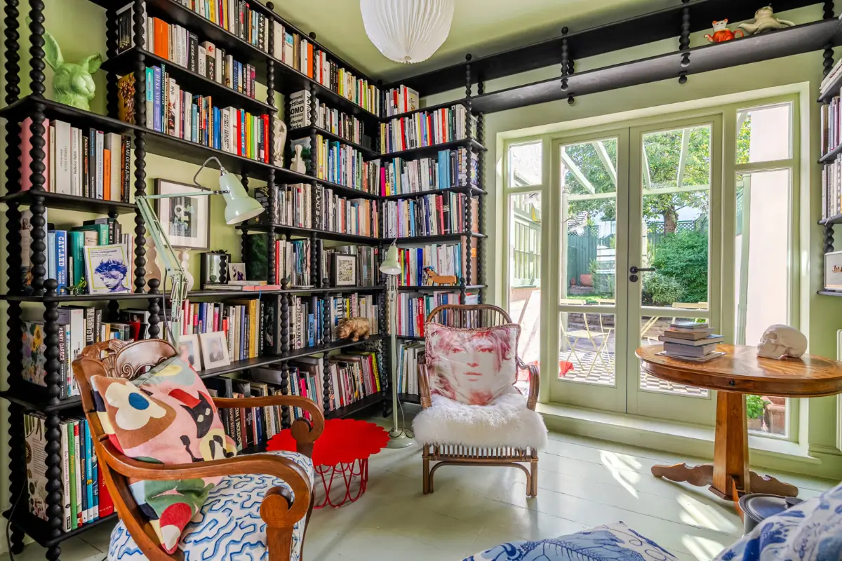 green-painted-floorboards-living-room-bookshelves-garden-doors